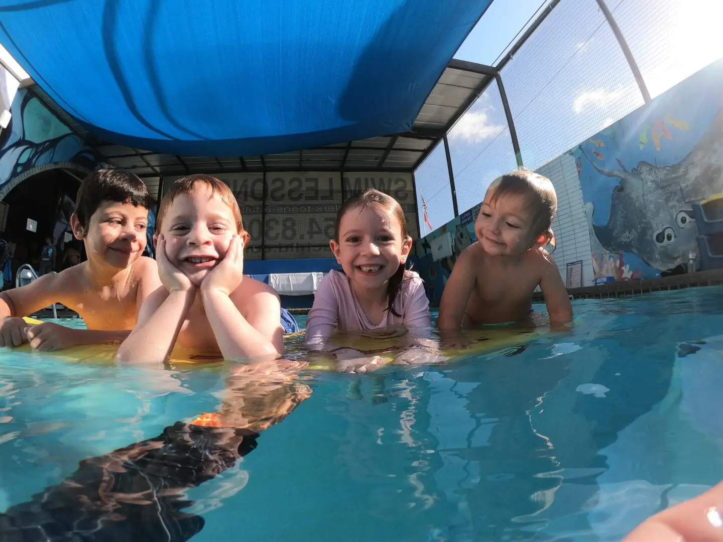 Four kids enjyoing swimming under water