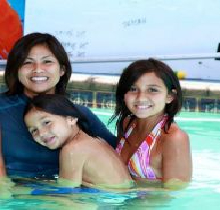 A woman and two girls in the water.